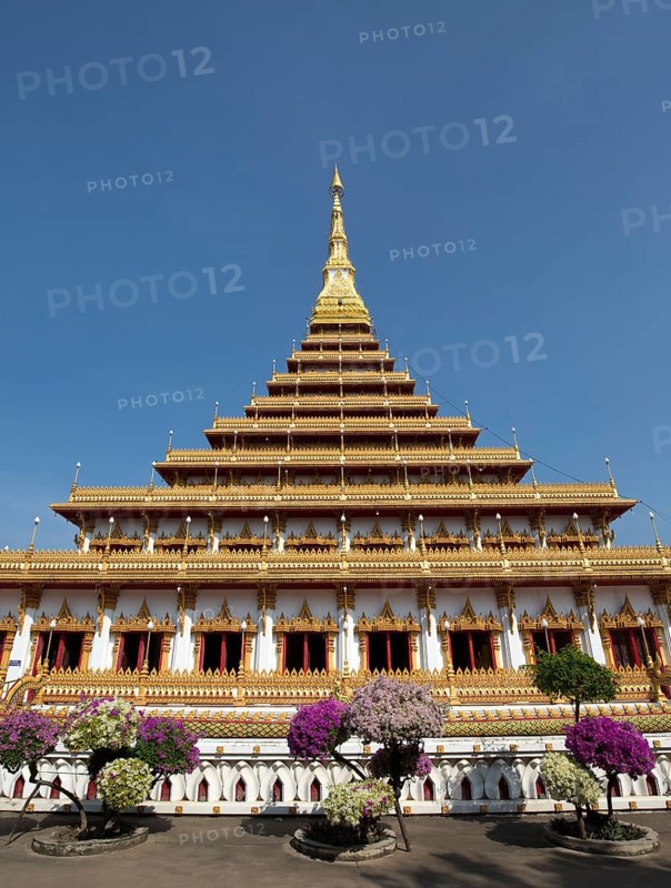 Flowering bushes in front of nine-story stupa Phra Mahathat Kaen Kakhon