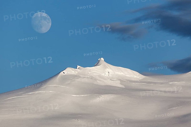 Snow-covered Snaefell volcano with Snaefellsjokul glacier and full moon