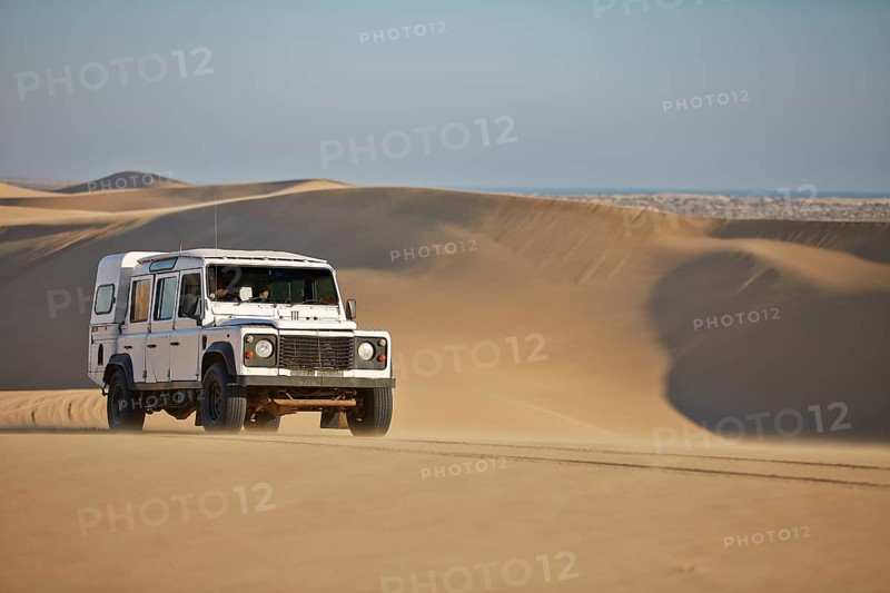 Off-road vehicle drives over sand dunes at Lange Wand on the Atlantic coast