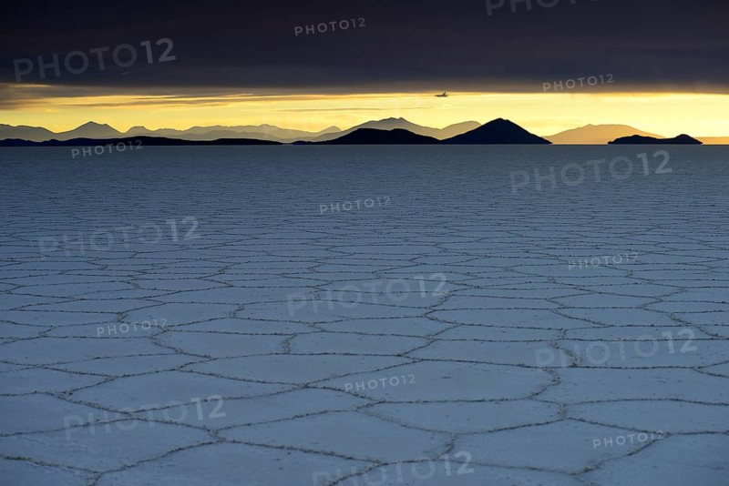 Honeycomb structure on the salt lake at sunset with clouds