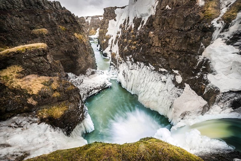 Partially icy waterfall in a canyon