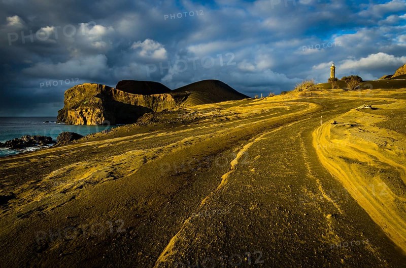 Rocky coast with lighthouse Farol da Ponta dos Capelinhos