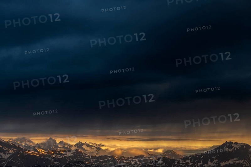 Sunrise over South Tyrolean mountains with dark rain clouds