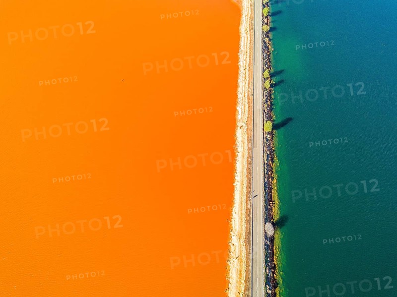 Street trough orange and blue lakes in mining region