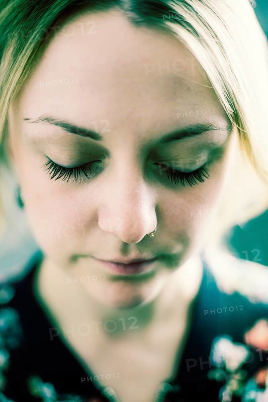 Young woman with closed eyes and nose piercing