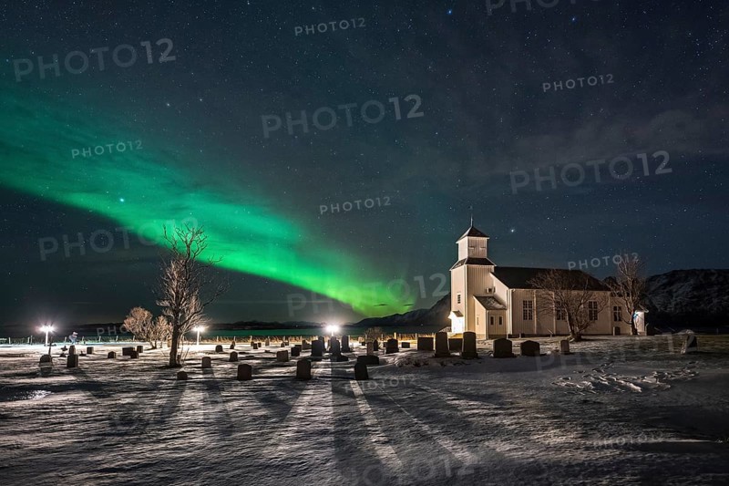 Northern lights over cemetery and church of Gimsoy