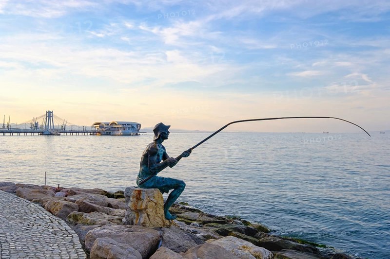 Bronze figure angler on waterfront