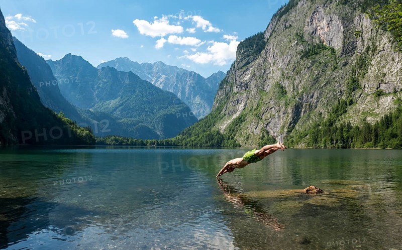 Young man jumps in lake Obersee