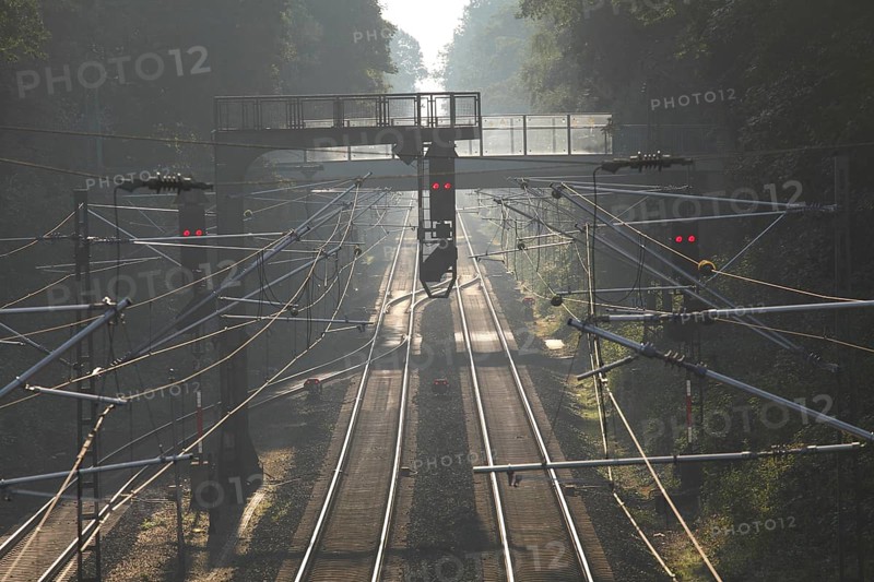 Railroad tracks with signals in morning fog