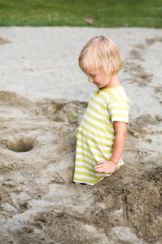 Toddler with 3 years on a playground in the sandbox