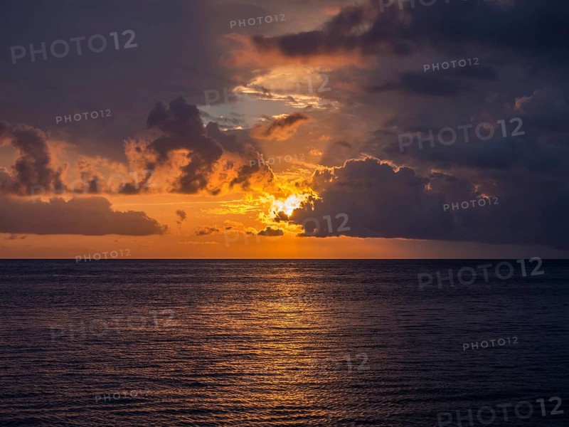 Sunset behind clouds over the sea off the coast of Levanto