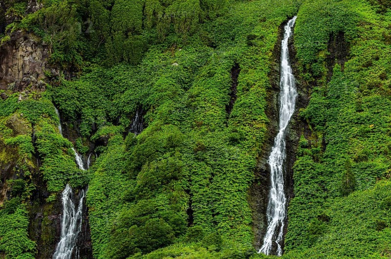 Waterfall Poco Ribeira do Ferreiro in green landscape