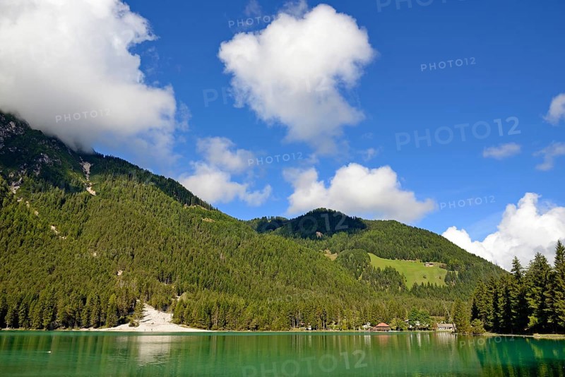 View over the emerald green lake Dobbiaco with mountain forest and Murengang