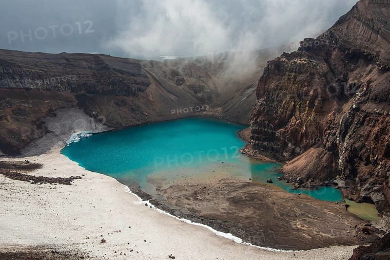 Steaming fumarole with crater lake on the Gorely volcano