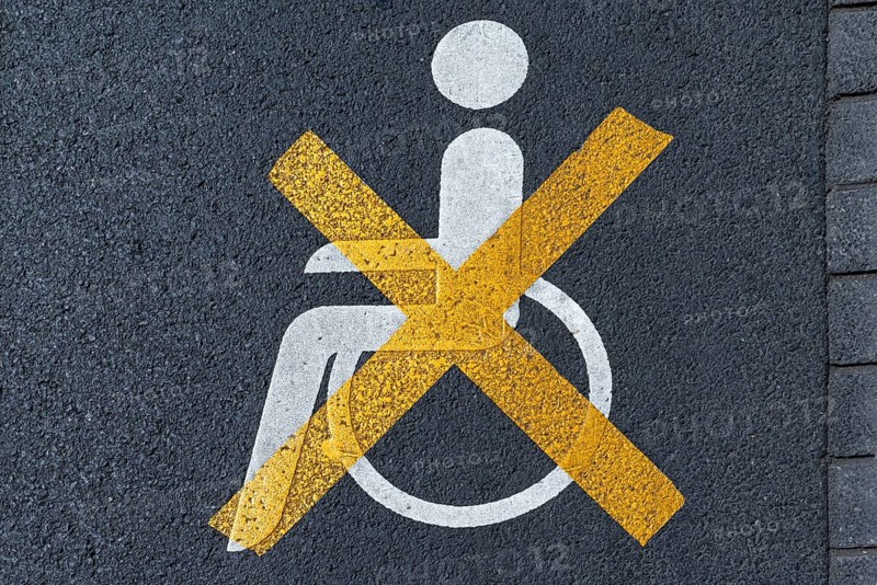 Crossed out disabled sign on a parking lot