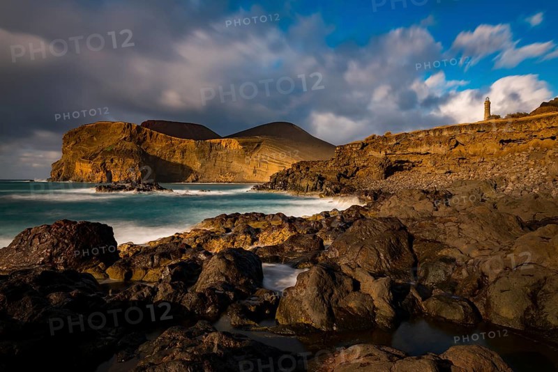Rocky coast with lighthouse Farol da Ponta dos Capelinhos