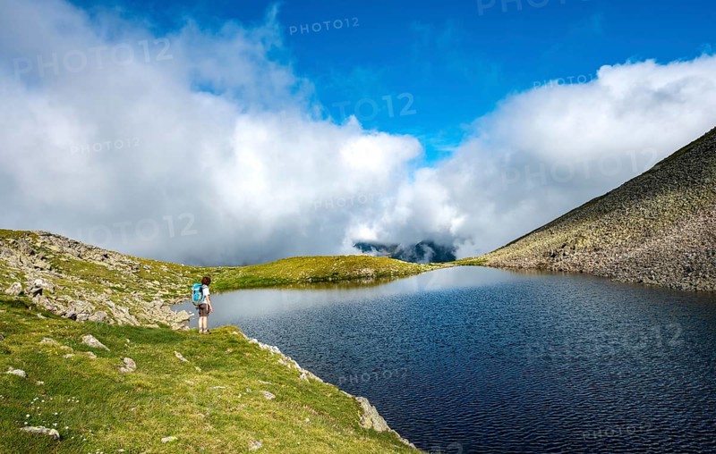 Hiker at Sattelsee lake at Greifenbergsattel