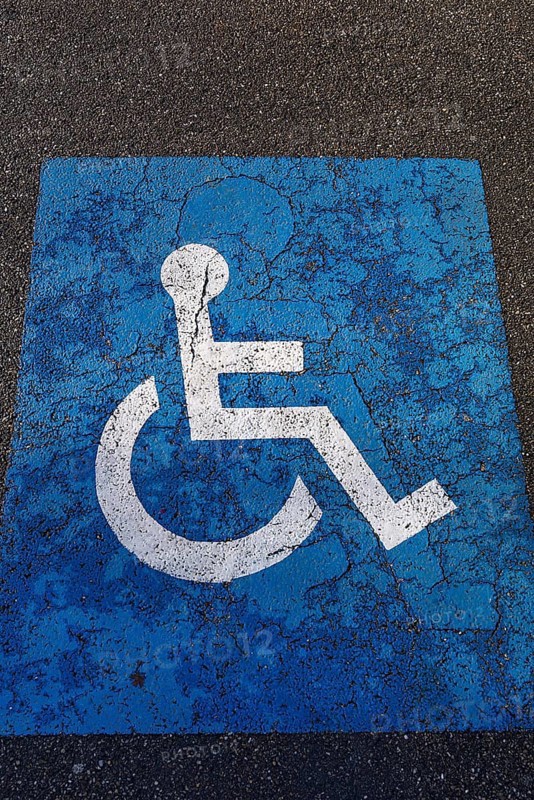 Sign for parking for people with disabilities on torn tar