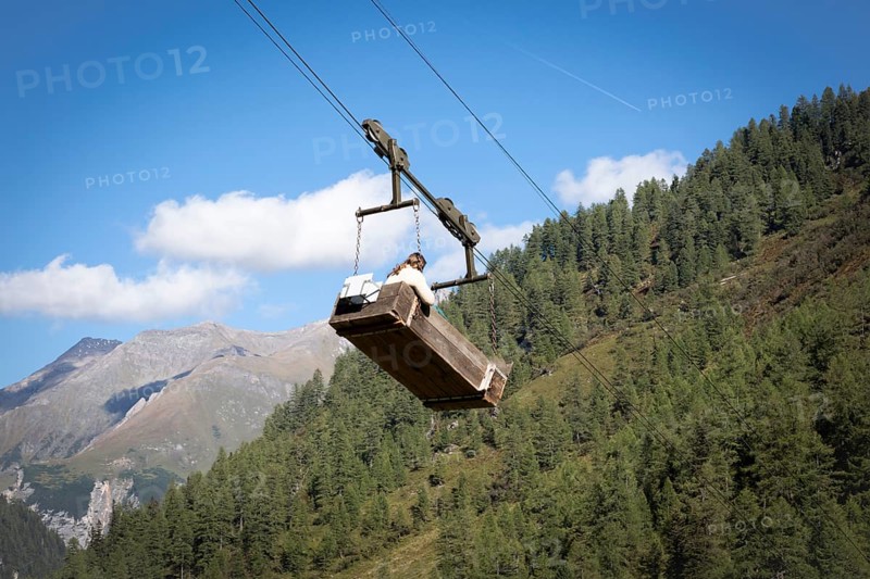 A woman travels in the material cable car of the Litzlhofalm in the Seidwinkl valley in the Hohe Tauern National Park