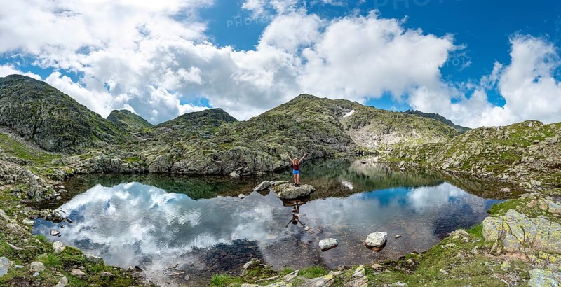 Hiker on a stone in a small lake