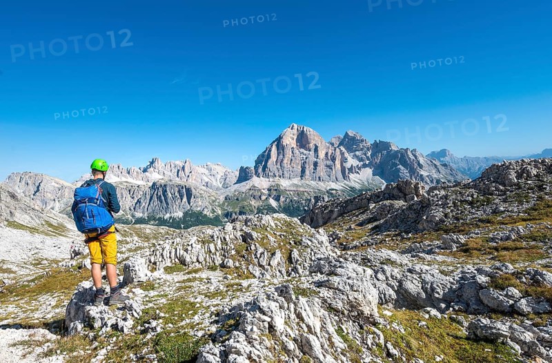 Hiker with climbing helmet on hiking trail to the Nuvolau