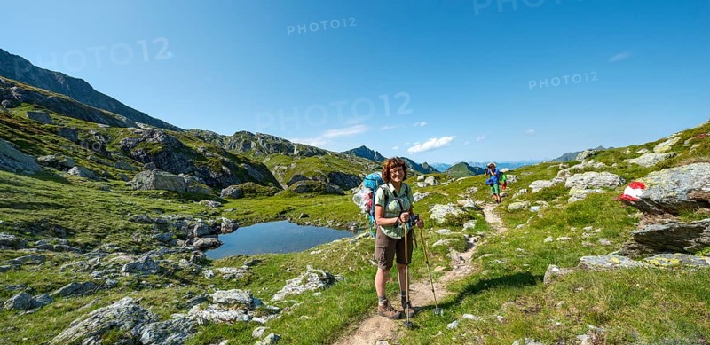 Two hikers at a small lake