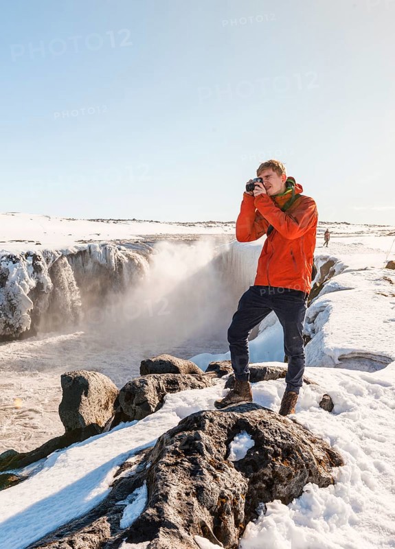 Photographing Man at Selfoss Waterfall in Winter