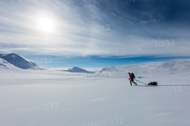 Ski tourer with pulka in the snow