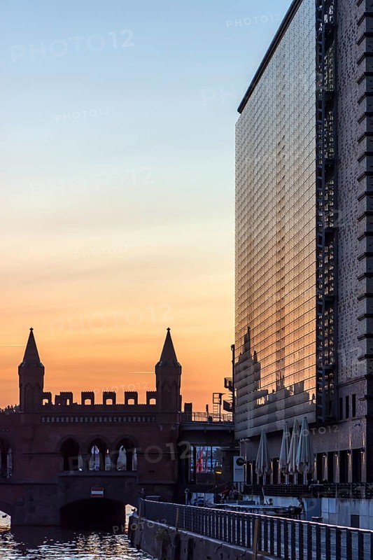 Modern skyscraper and Oberbaum bridge in the evening light