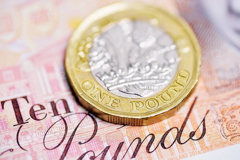 Pound coin on a ten pound note