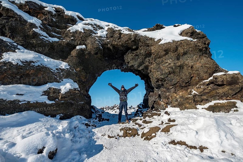 Man standing in front of a rocky arch