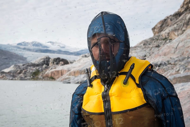 Man with mosquito net at fjord