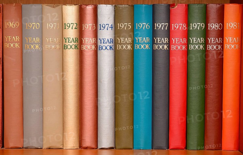 Year-books in different colors in a shelf