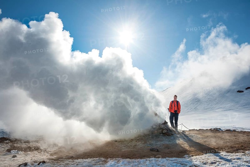 Young man standing by a steaming fumarole