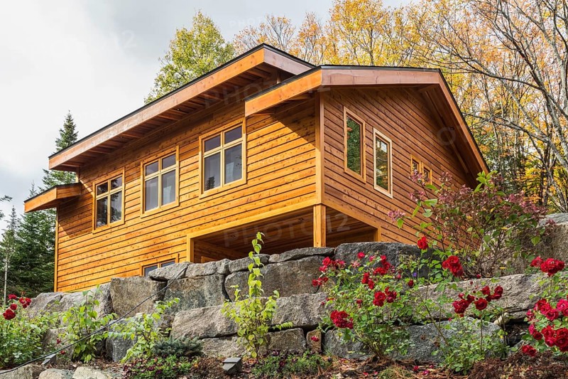 Luxurious stained cedar and timber wood 2-car garage with upstairs floor and landscaping in autumn