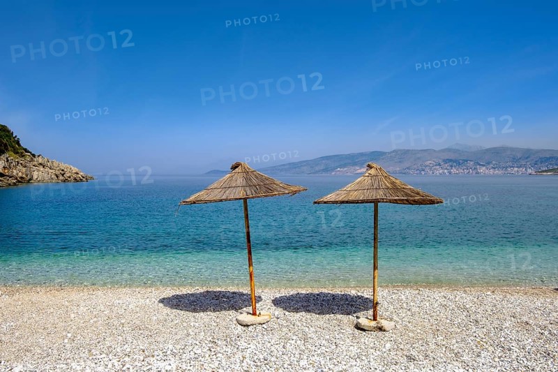 Reed-covered parasols on the gravel beach