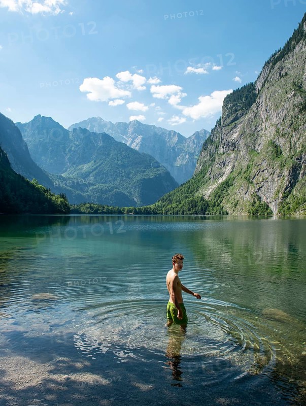 Young man bathes in lake Obersee