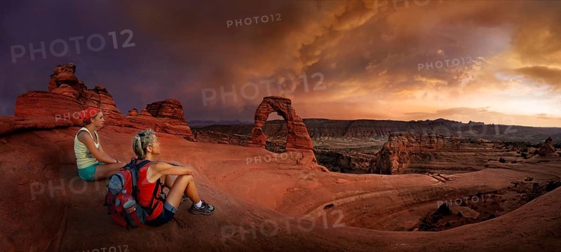 Hikers sit at Delicate Arch Arch