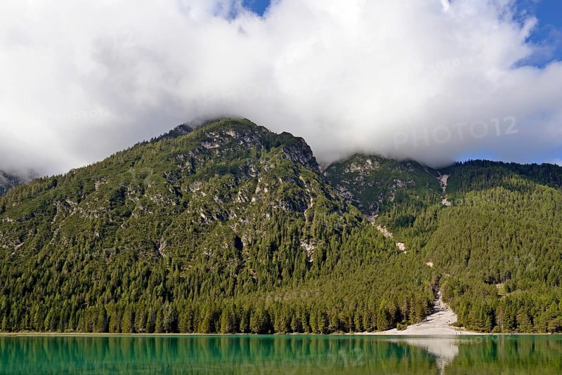 View over the emerald green lake Dobbiaco with mountain forest and Murengang
