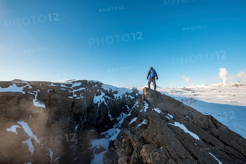 Mountain hiker stands at Continental Rift between North American and Eurasian Plate