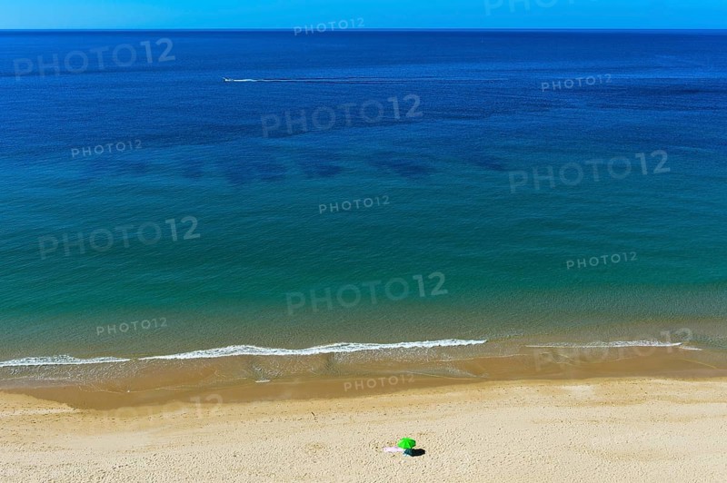 Solitary parasol on an empty sandy beach near Praia da Luz