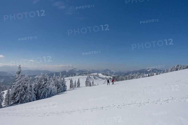 Ski mountaineers in a snowy landscape to Unterberg
