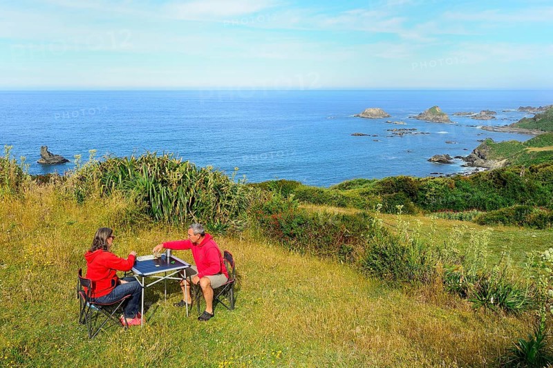 Couple plays board game on camping table