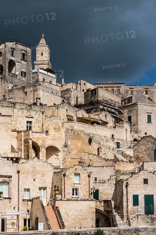Houses with cathedral Maria Santissima della Bruna with dark cloudy sky