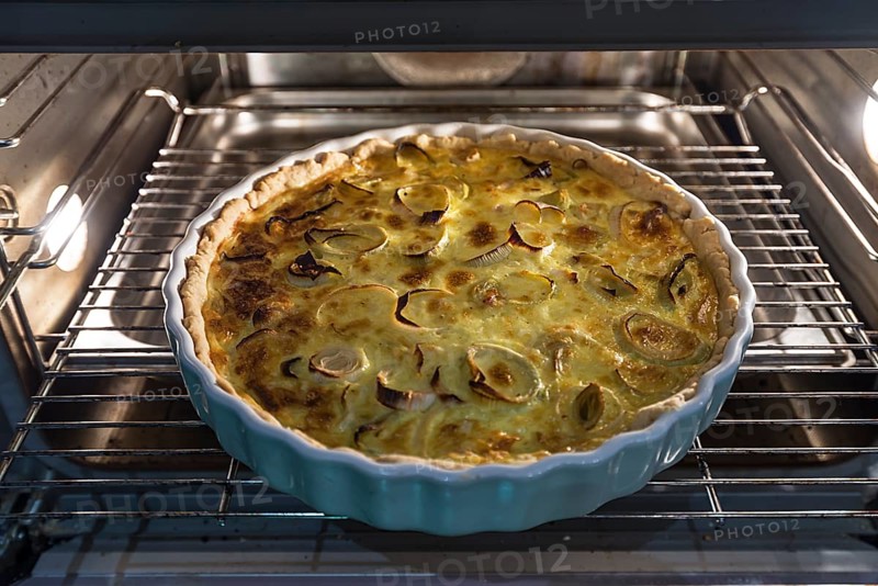 Baked leek quiche in round form in the oven
