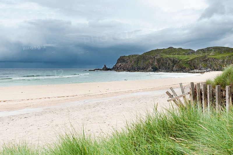 Sandy beach with dark clouds over the coast
