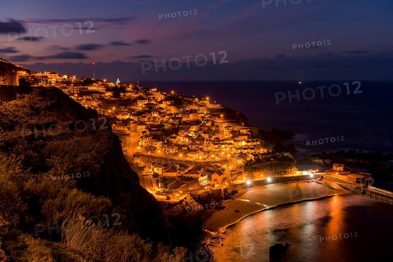 Blue hour with illuminated town by the sea