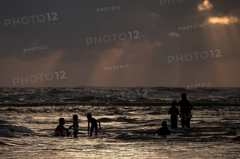 People in backlight in water