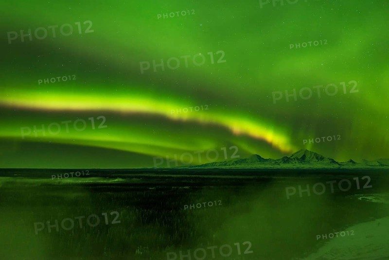 Aurora over the fog shrouded Copper River and mounts Sanford Drum and Wrangell