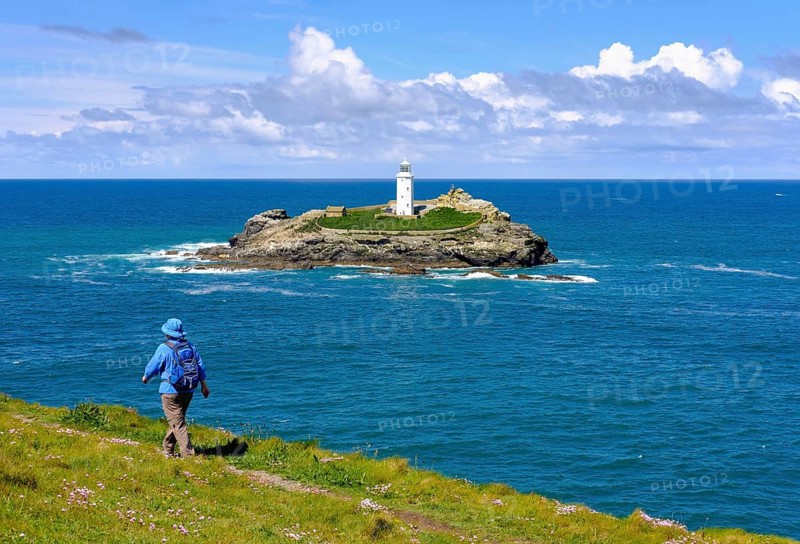 Woman hikes on coastal route at Godrevy Point